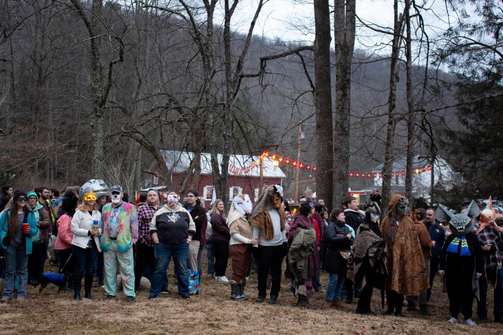 A crowd of people stand outside during the mask contest.